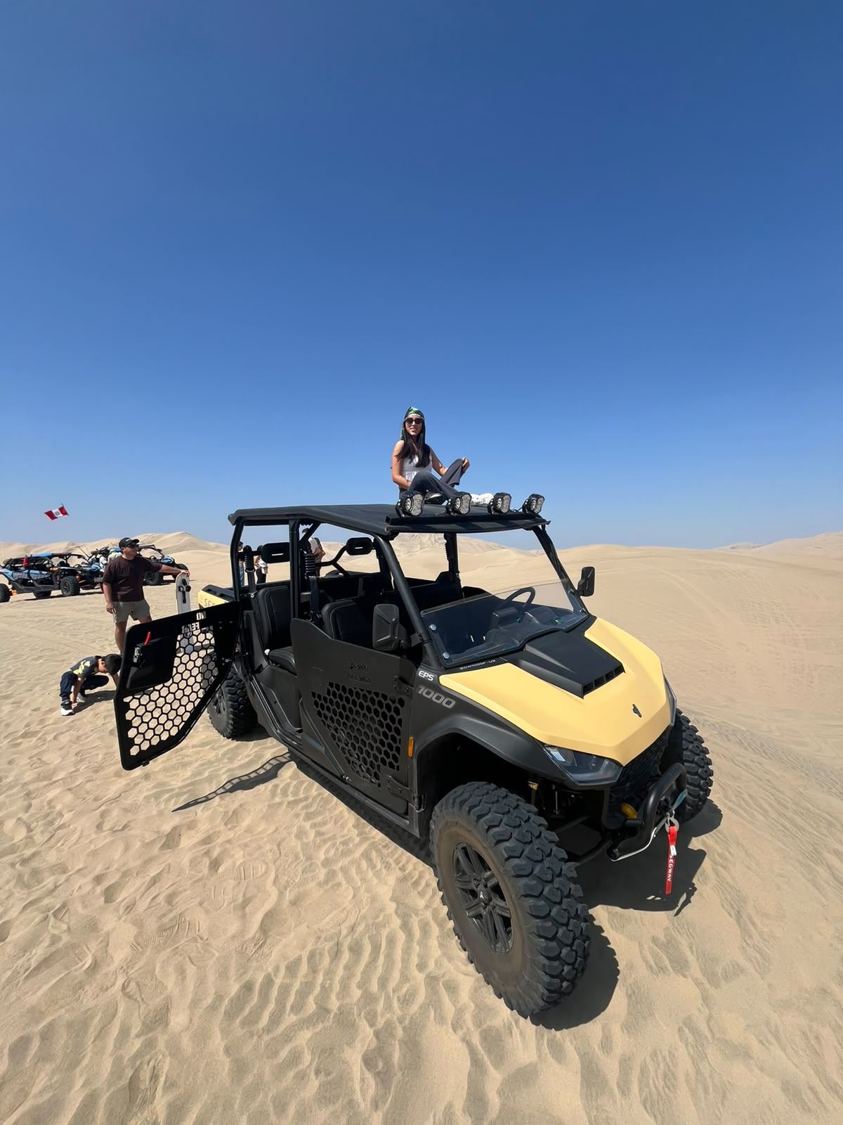 Grupo con un UTV de puertas abiertas en las dunas del desierto de Ica