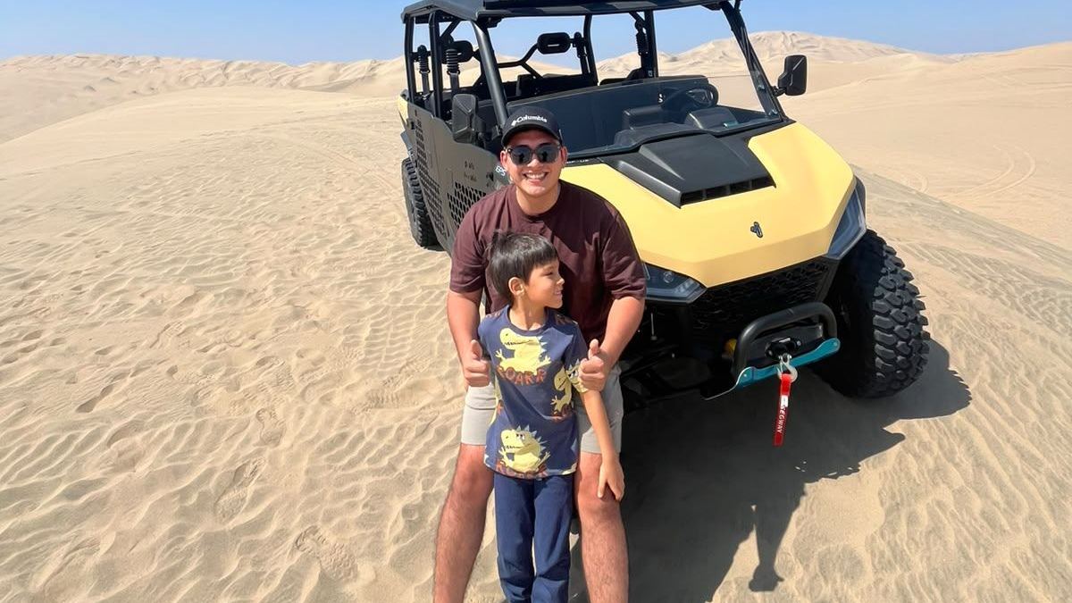 A father and his son in front of a UTV in the Huacachina desert
